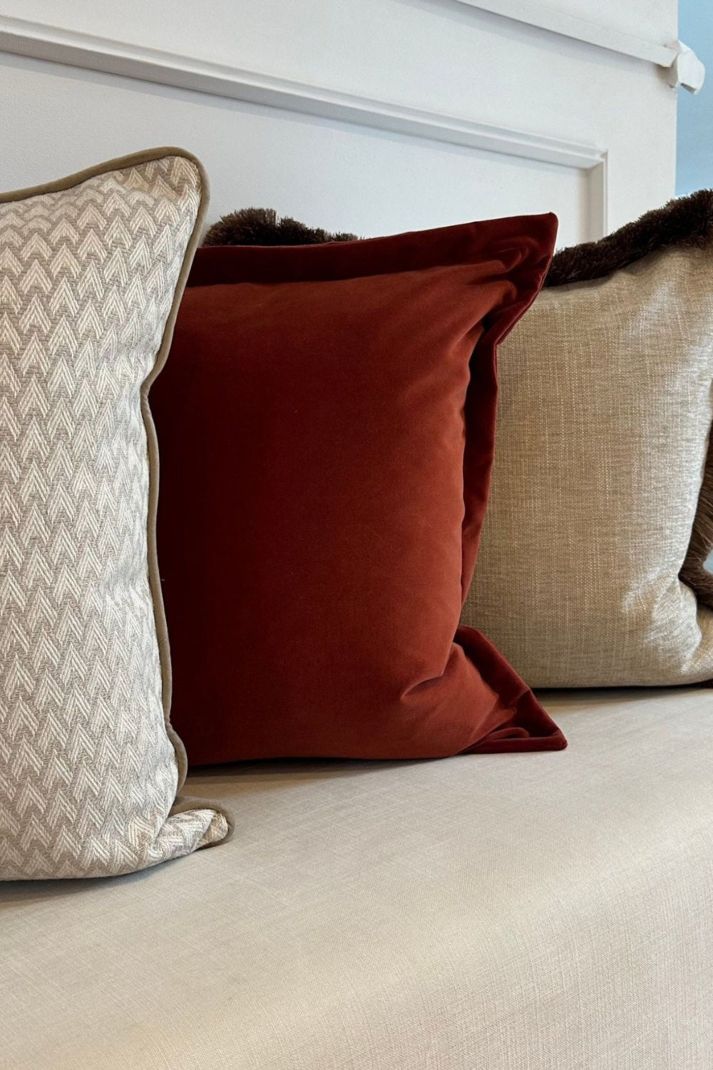 Close-up of decorative pillows on a sofa with a neutral background