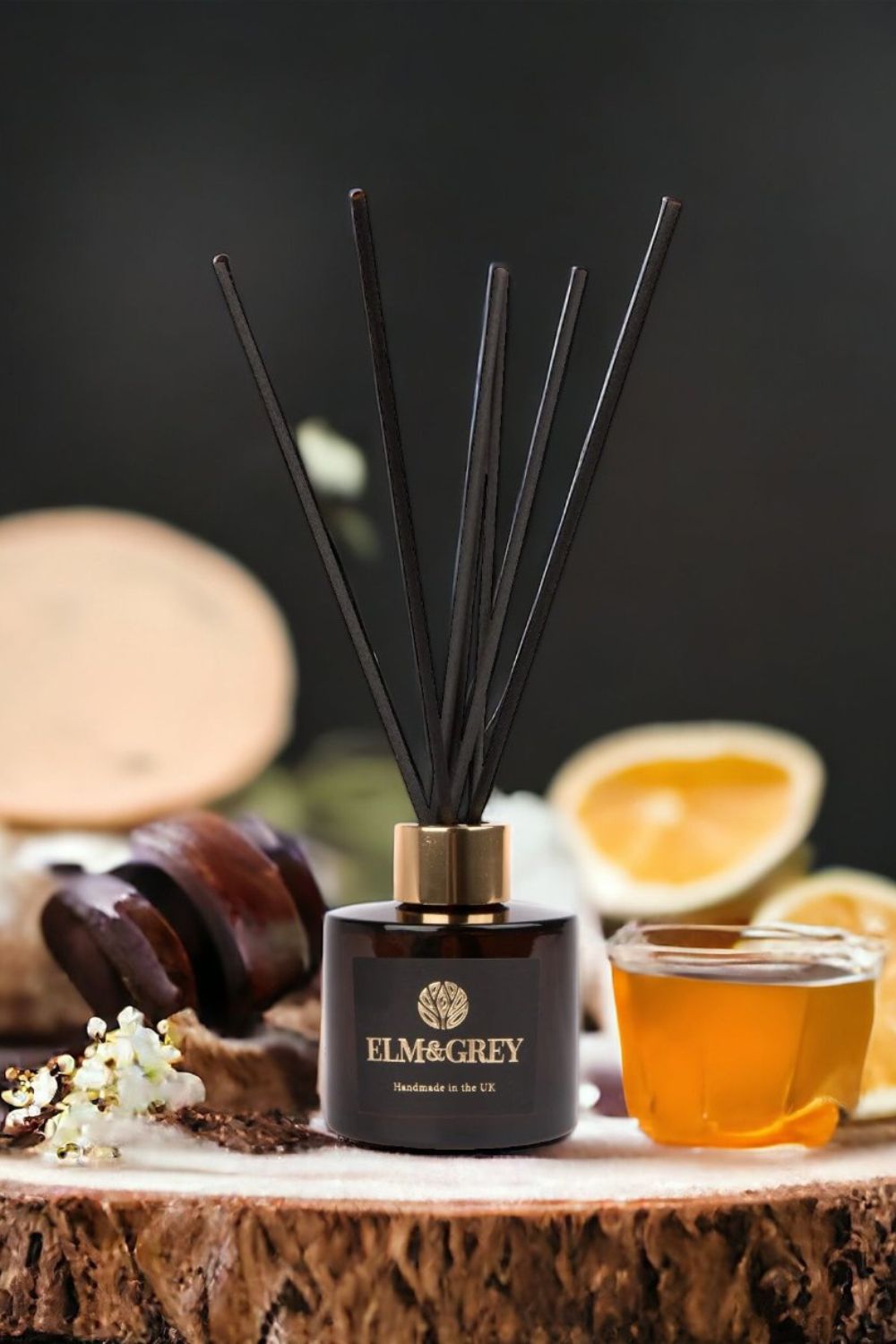 Diffuser with black reeds on a wooden surface with a dark background