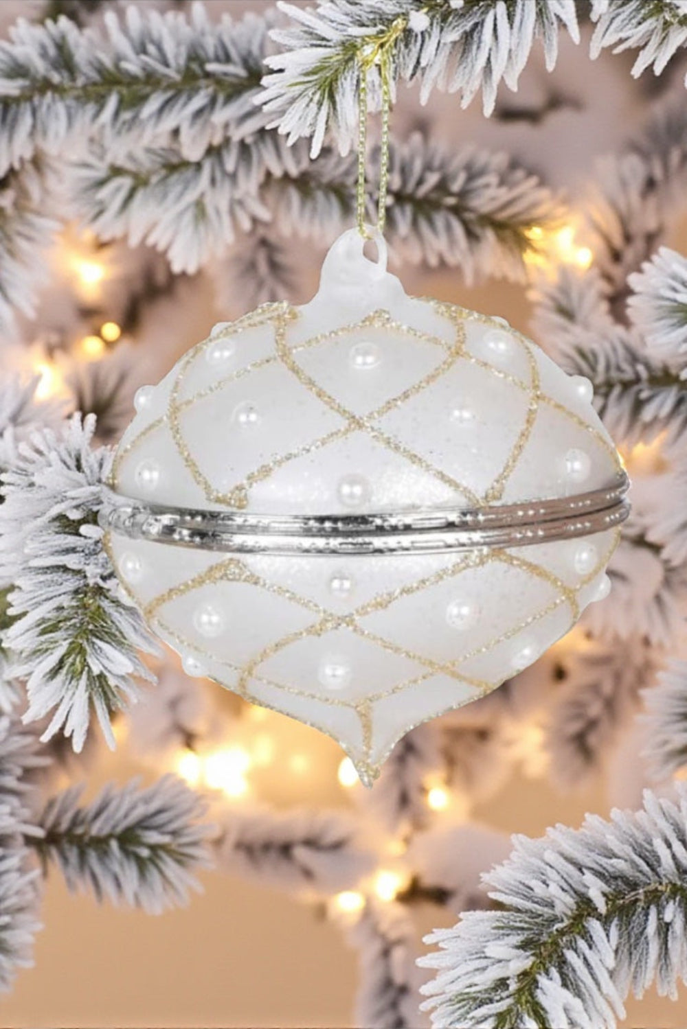 Decorative white ornament with gold patterns on a Christmas tree.