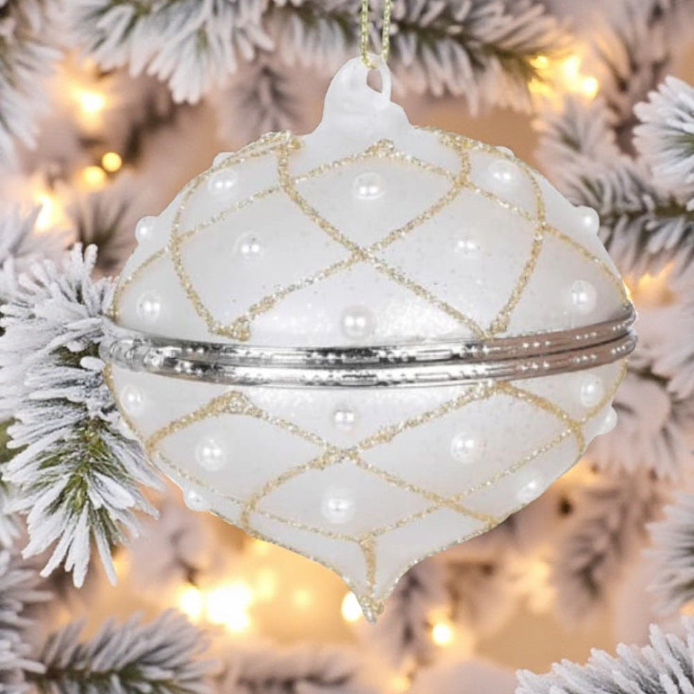 Decorative white ornament with gold patterns on a Christmas tree.