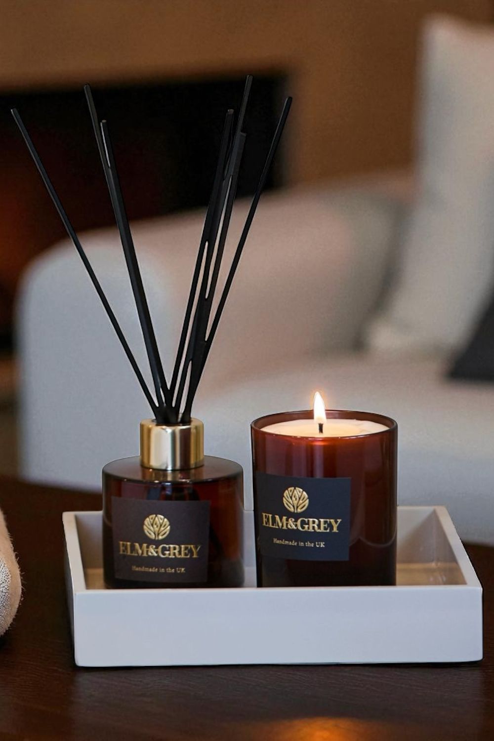 Elm & Grey candle and diffuser set on a tray with a blurred background