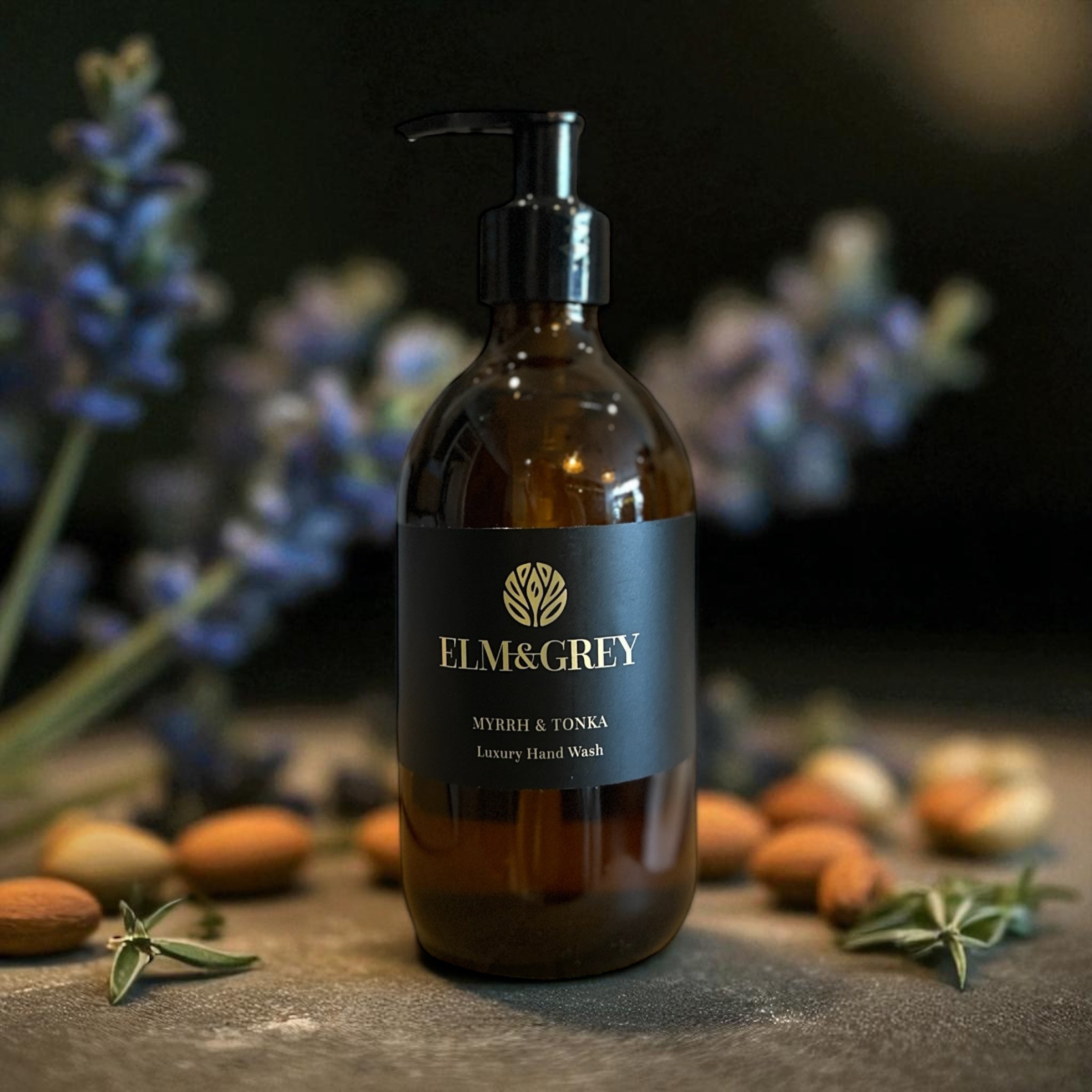 Brown bottle of Elm & Grey luxury hand wash with flowers and nuts in the background