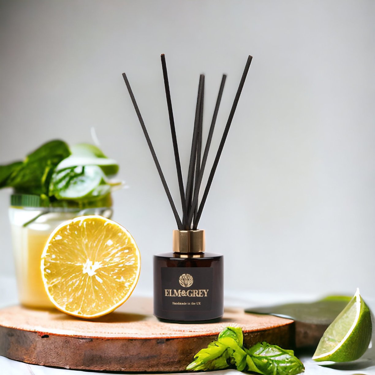 Amber Reed Diffuser surrounded by Lime and basil