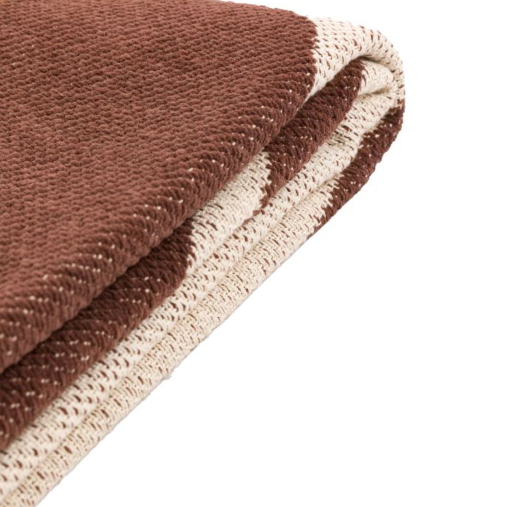 Close-up of a brown and cream textured fabric on a white background