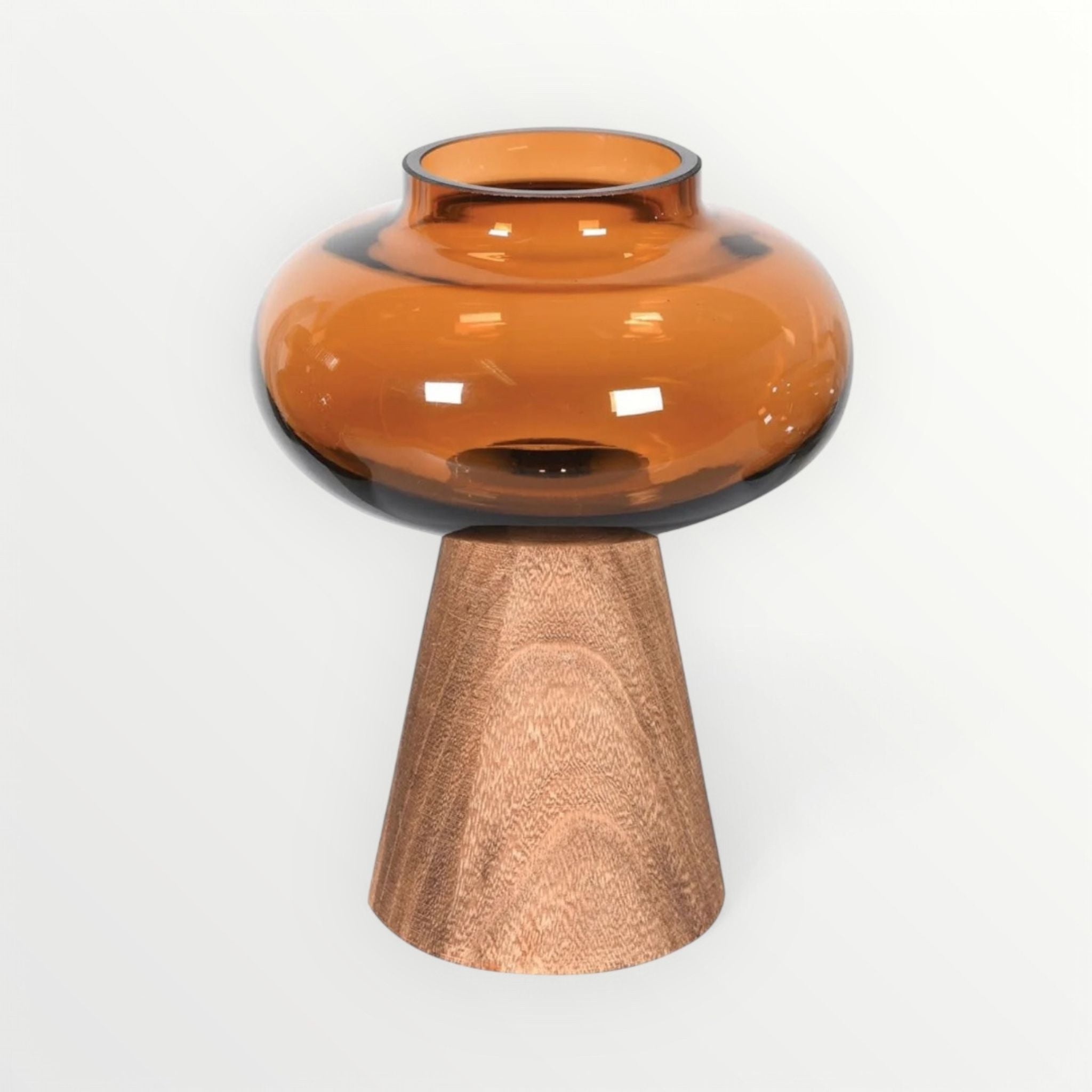 Amber glass vase with a wooden base on a white background