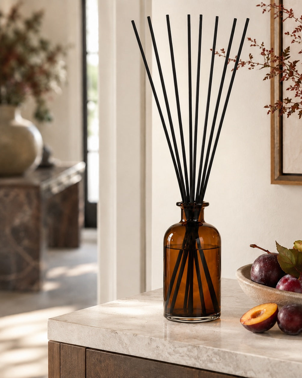 Elm & Grey Black Plum & Rhubarb Statement Reed Diffuser with amber glass vessel and black reeds styled on a console table for large room home fragrance