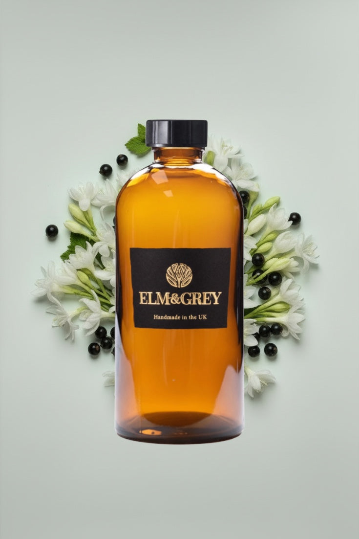 diffuser refill liquid surrounded by flowers and berries on a light background