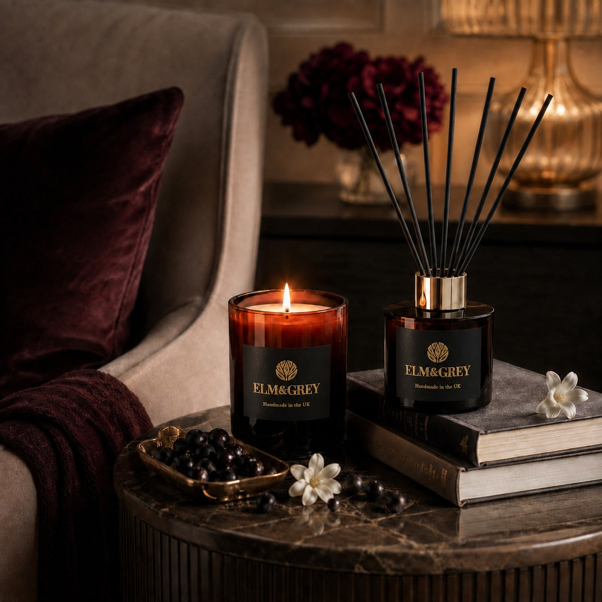 Elm & Grey Blackcurrant & Tuberose candle and reed diffuser styled in a warm elegant living space