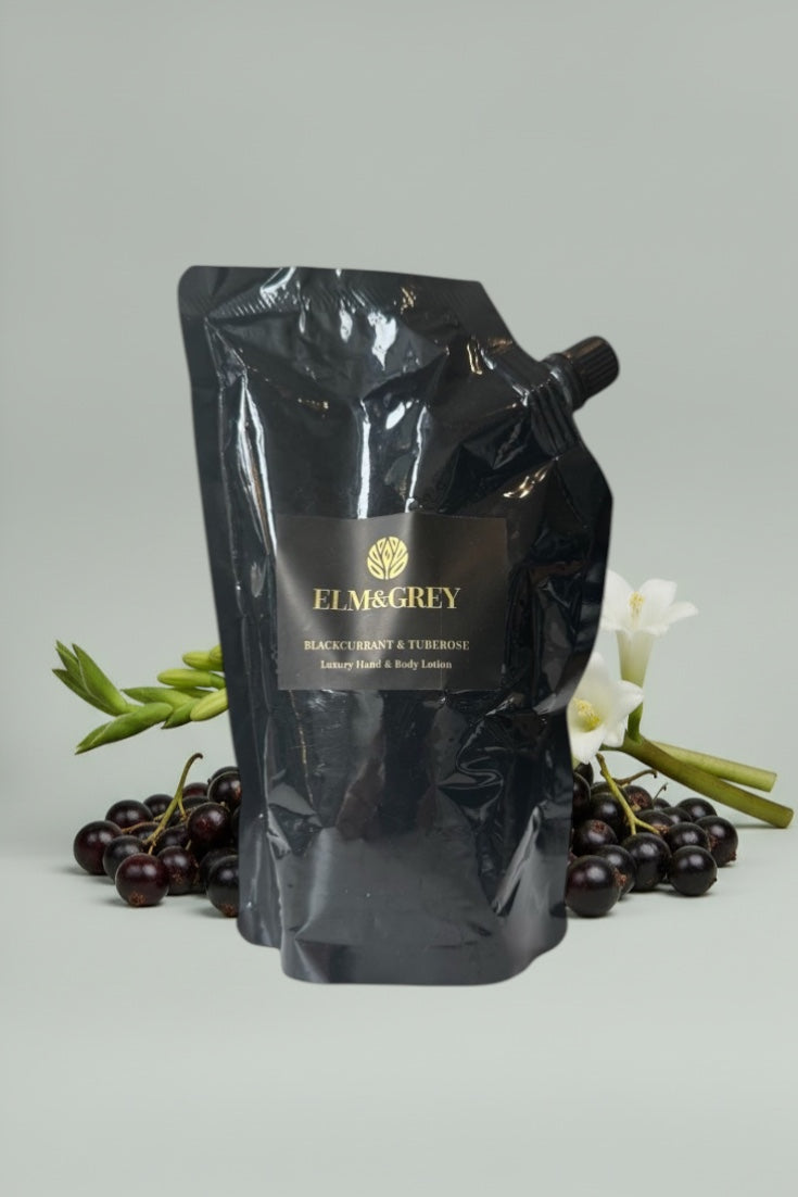 Black pouch with elm and grey branding on a light grey background with berries and flowers.