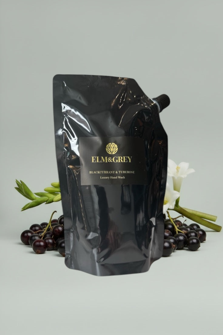 Black pouch with Elm & Grey branding on a light gray background with blackberries and green leaves.