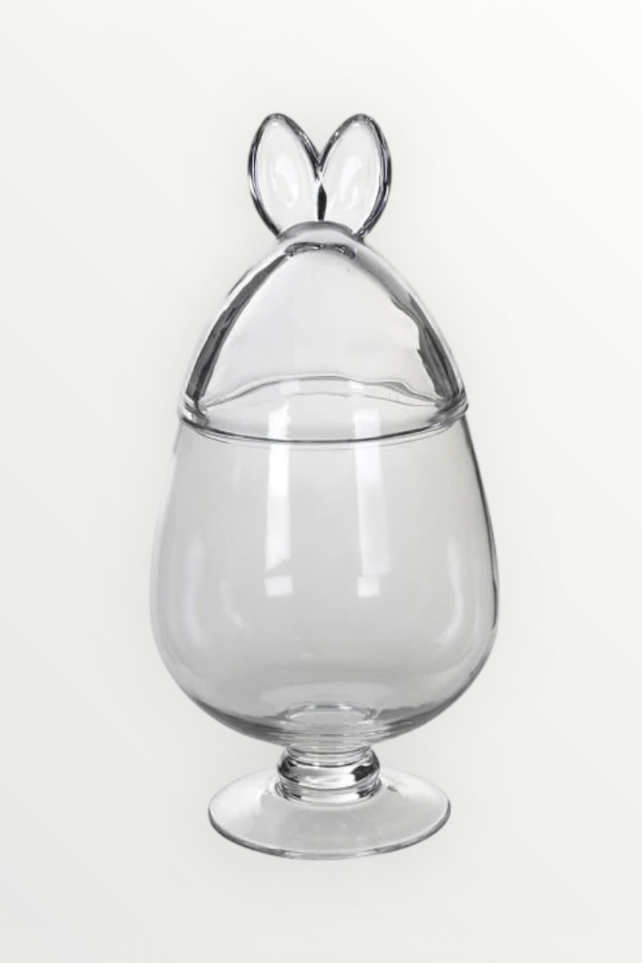 Clear glass container with a bunny-shaped lid on a white background