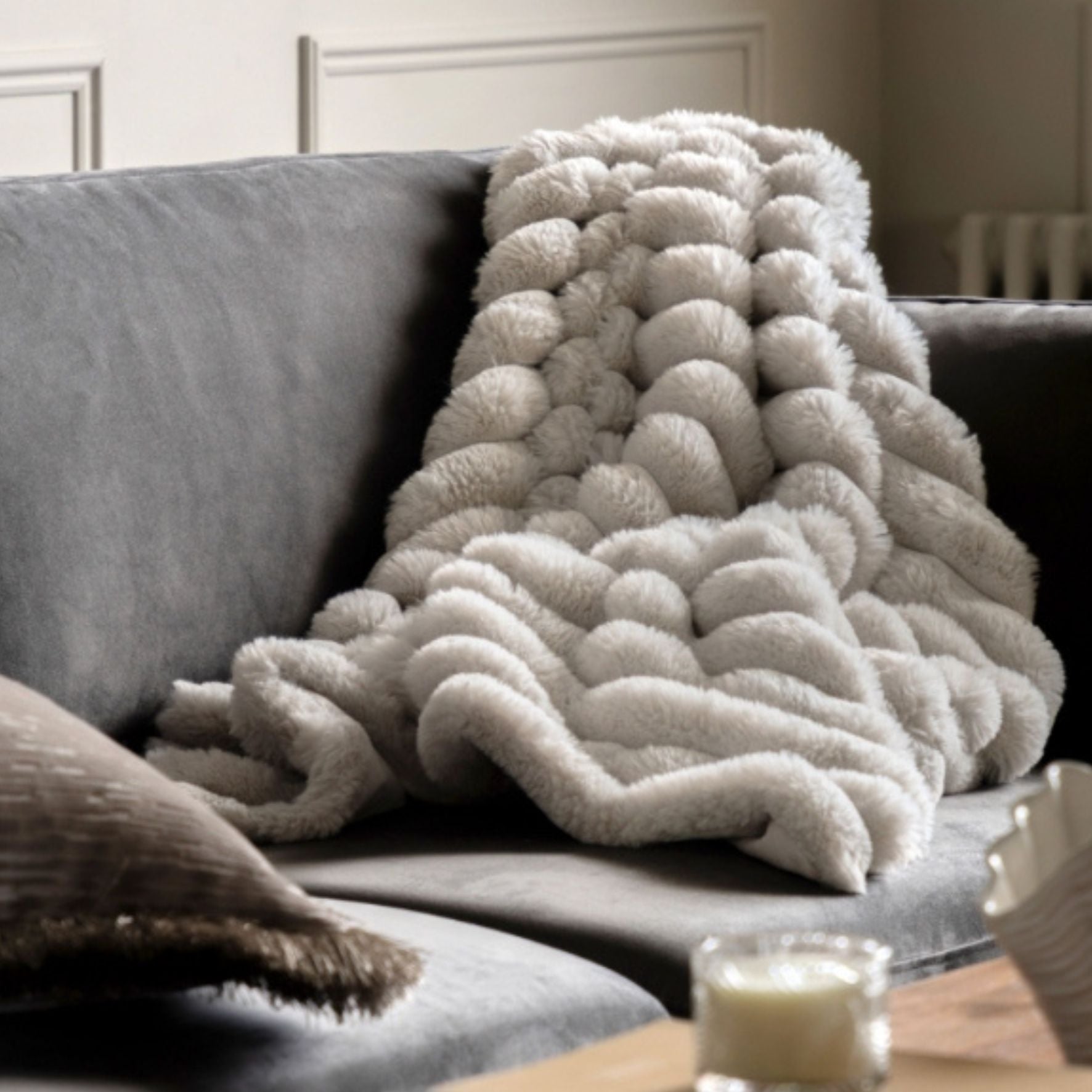 Textured blanket draped over a sofa in a cozy living room setting.