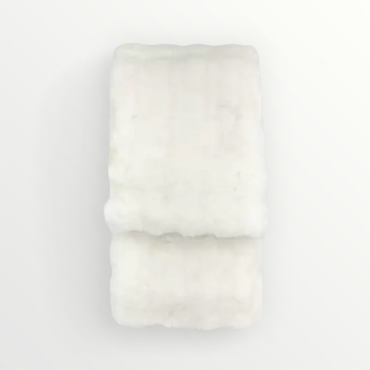 A creamy white faux fur cushion with a plush texture, displayed against a white background.