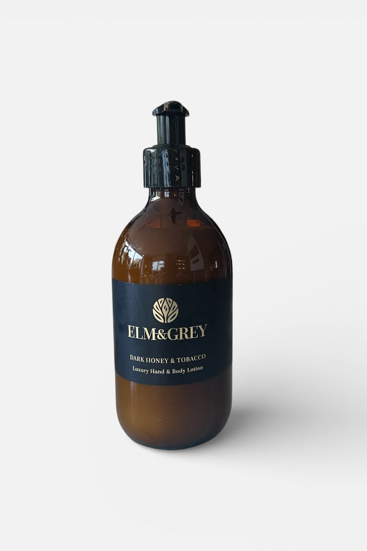 Dark honey and tobacco fragranced Amber bottle with pump dispenser labeled 'Elm&Grey' on a white background