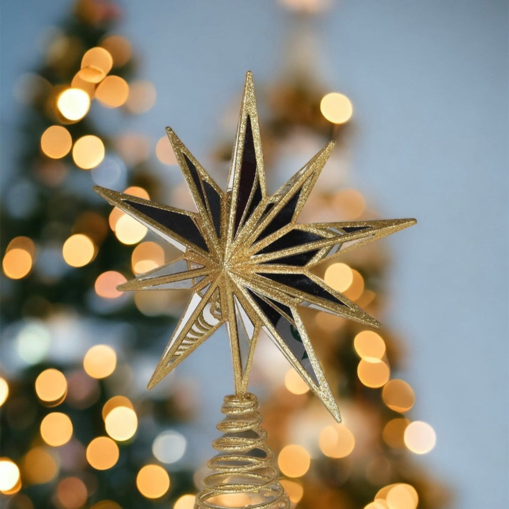 Decorative star ornament on a Christmas tree with blurred lights in the background