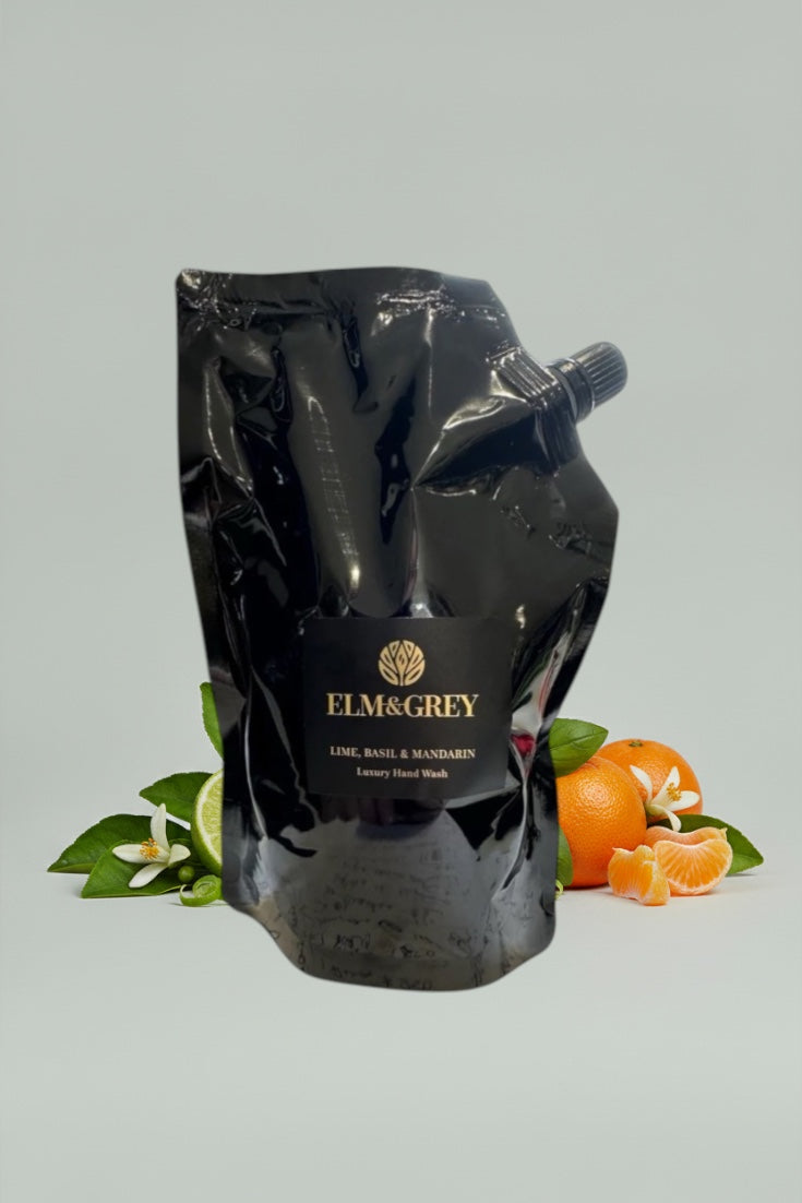 Black pouch with 'Elm & Grey' branding on a light grey background with oranges and leaves.