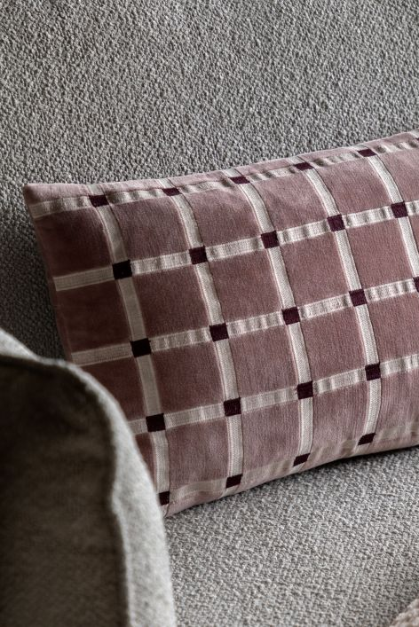 mauve cushon in a grid pattern on a sofa