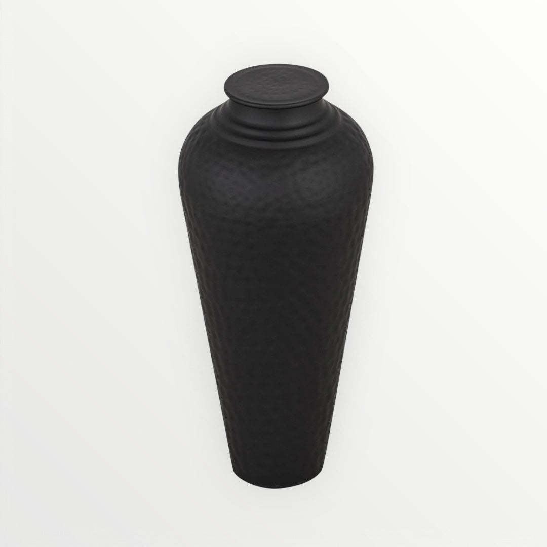 A matte black, medium-sized, hammered steel vase