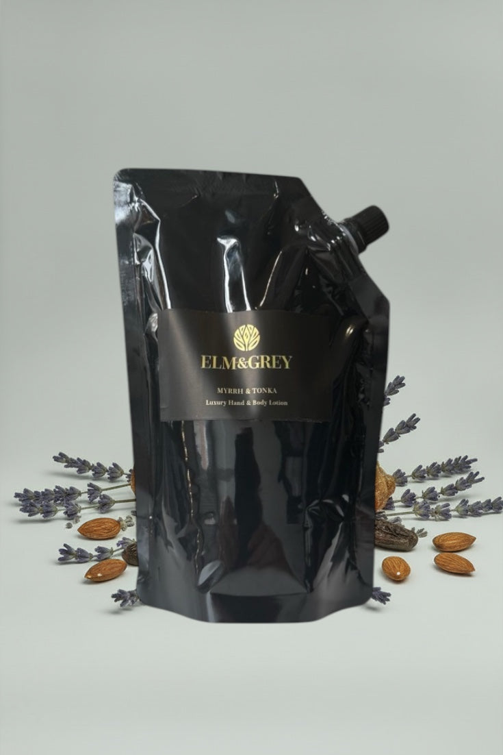 Black refill pouch with Elm and Grey branding on a light grey background with almonds and lavender.