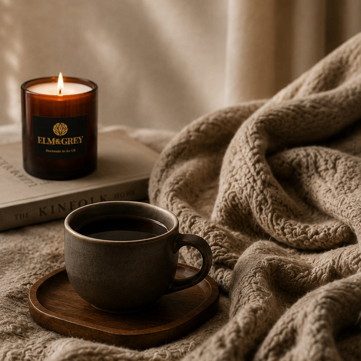 Elm & Grey Myrrh & Tonka candle styled with a warm drink and soft neutral textiles