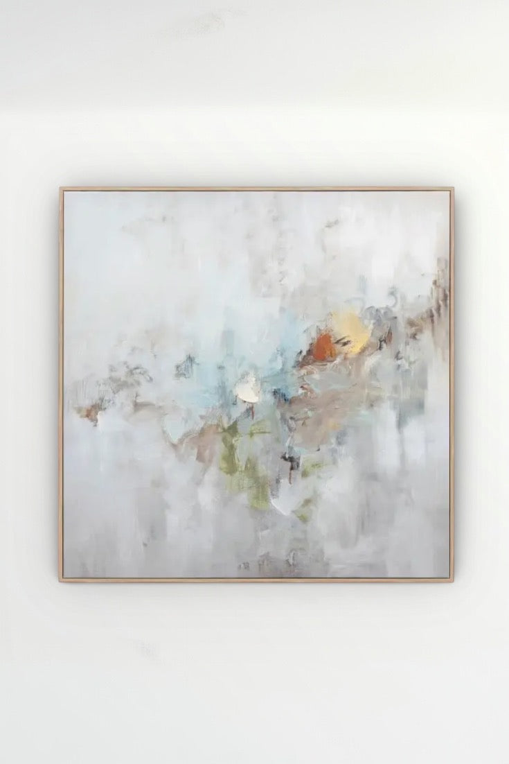 Abstract painting in a gold frame on a white wall