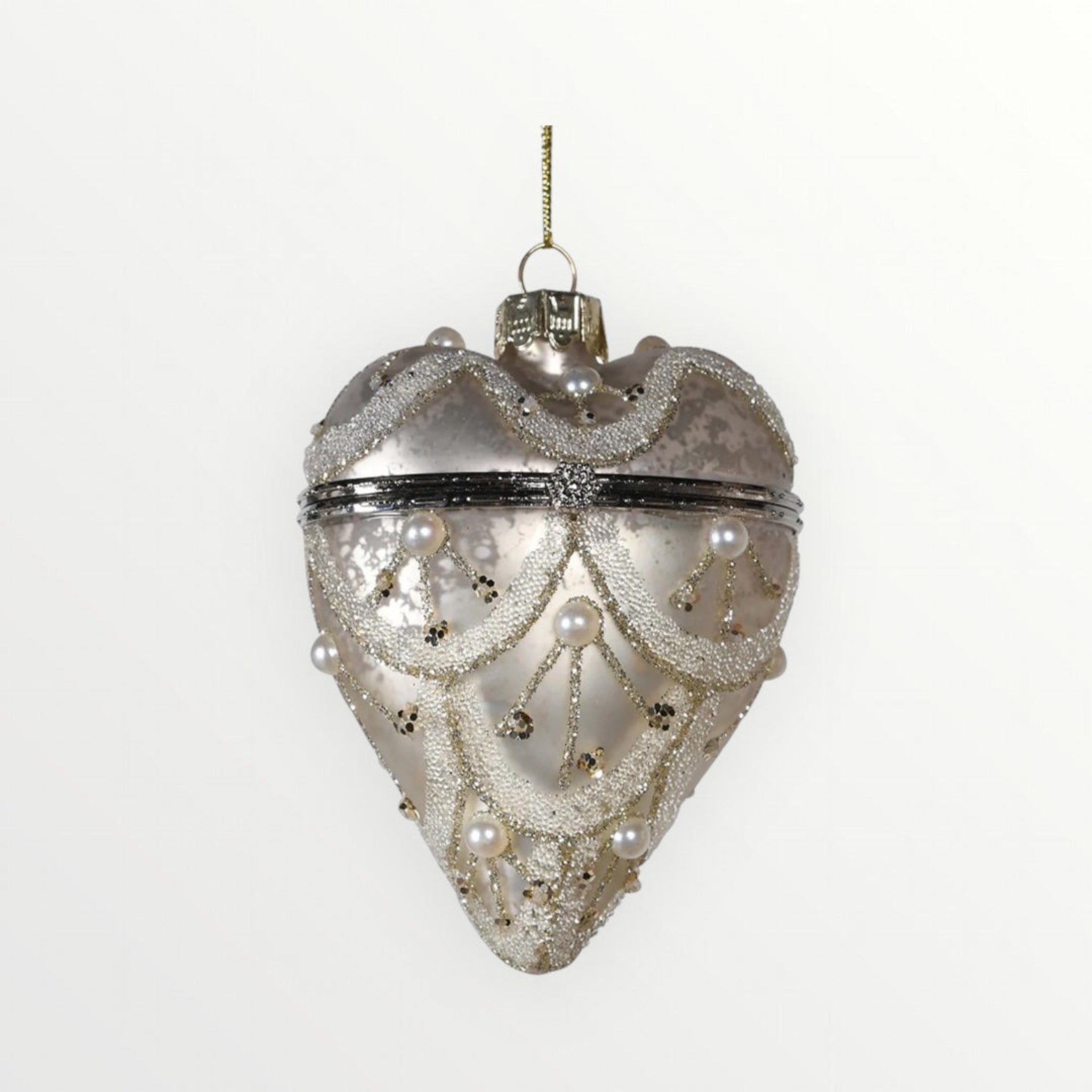 Decorative heart-shaped ornament with pearls and glitter on a white background