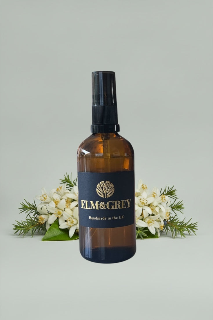 Room spray in amber glass bottle on a grey background