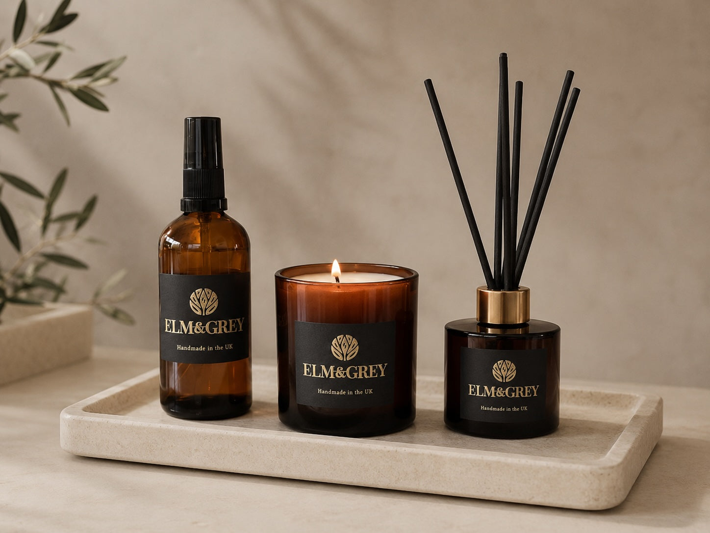 elm and grey room spray candle and reed diffuser on a cream marble tray with a neutral background