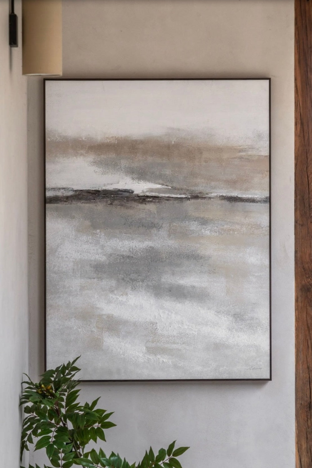 Abstract landscape painting in a frame on a wall with a plant in the foreground by Elm & Grey