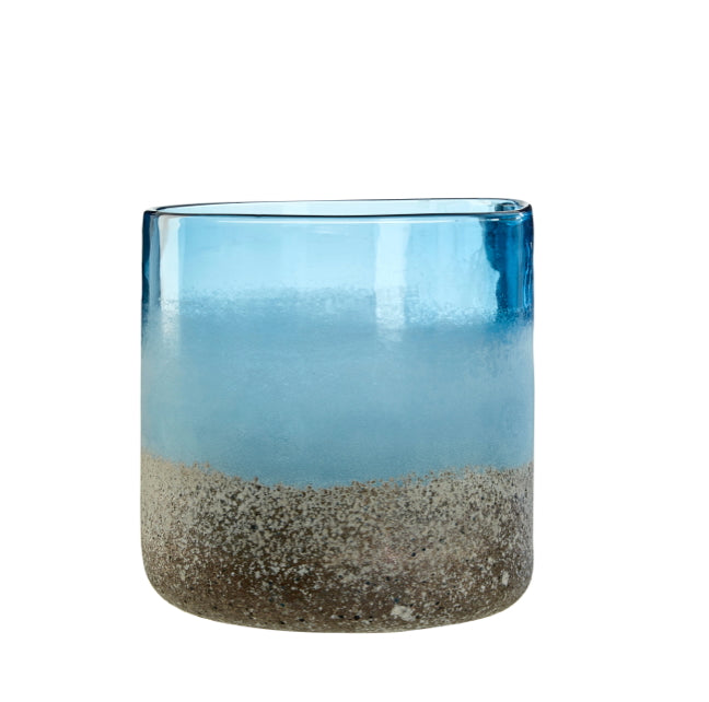 Blue textured glass candle holder with sandy bottom on a white background