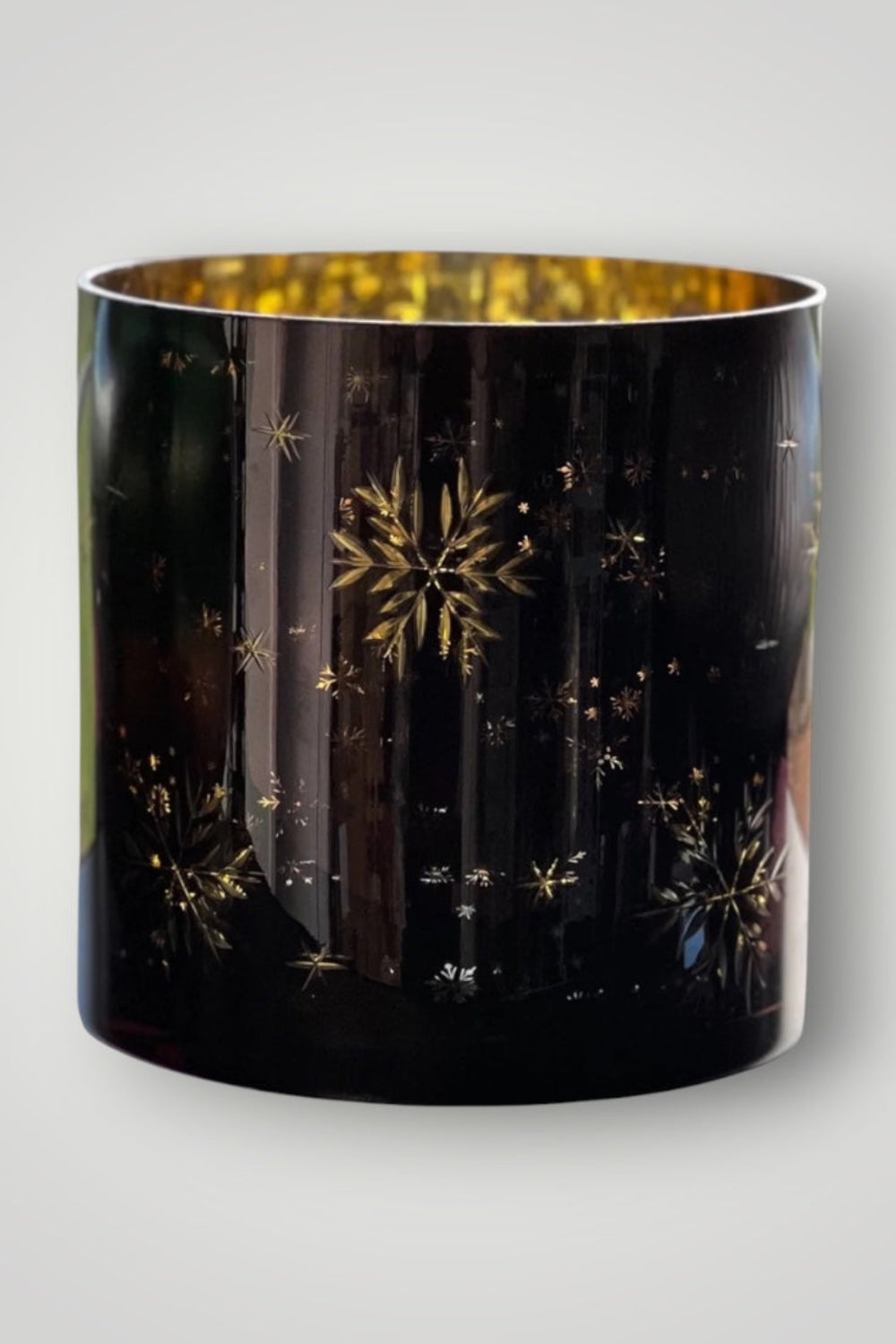 Black cylindrical container with gold star patterns on a light gray background