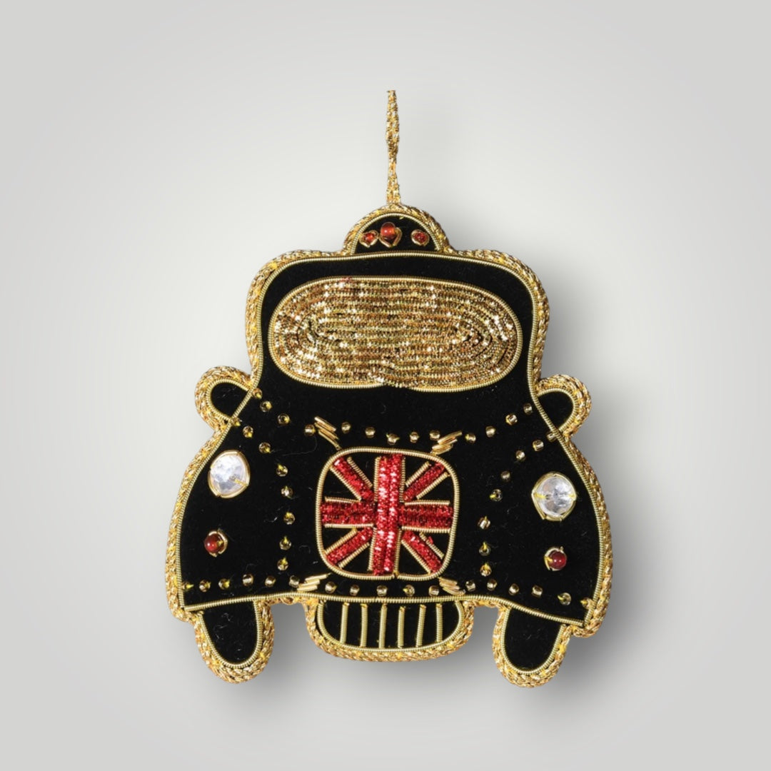 Decorative ornament shaped like a black car with gold accents and a Union Jack flag on a gray background.