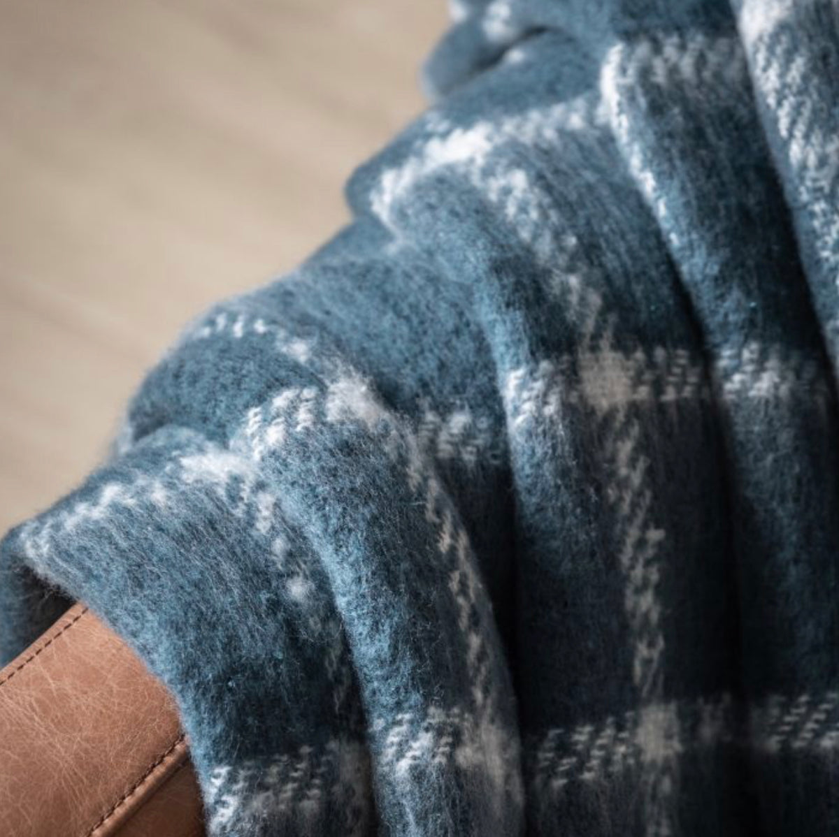Close-up of a blue mohair blanket with a pattern on an armchair