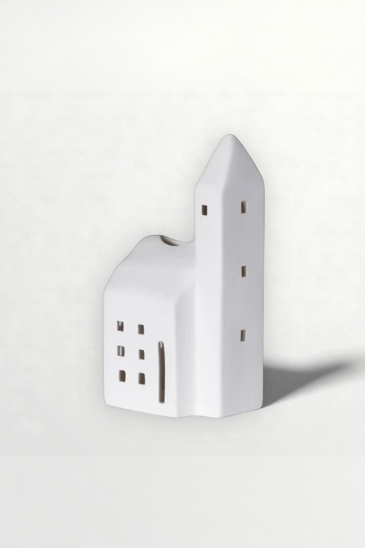 White ceramic house-shaped object on a light gray background
