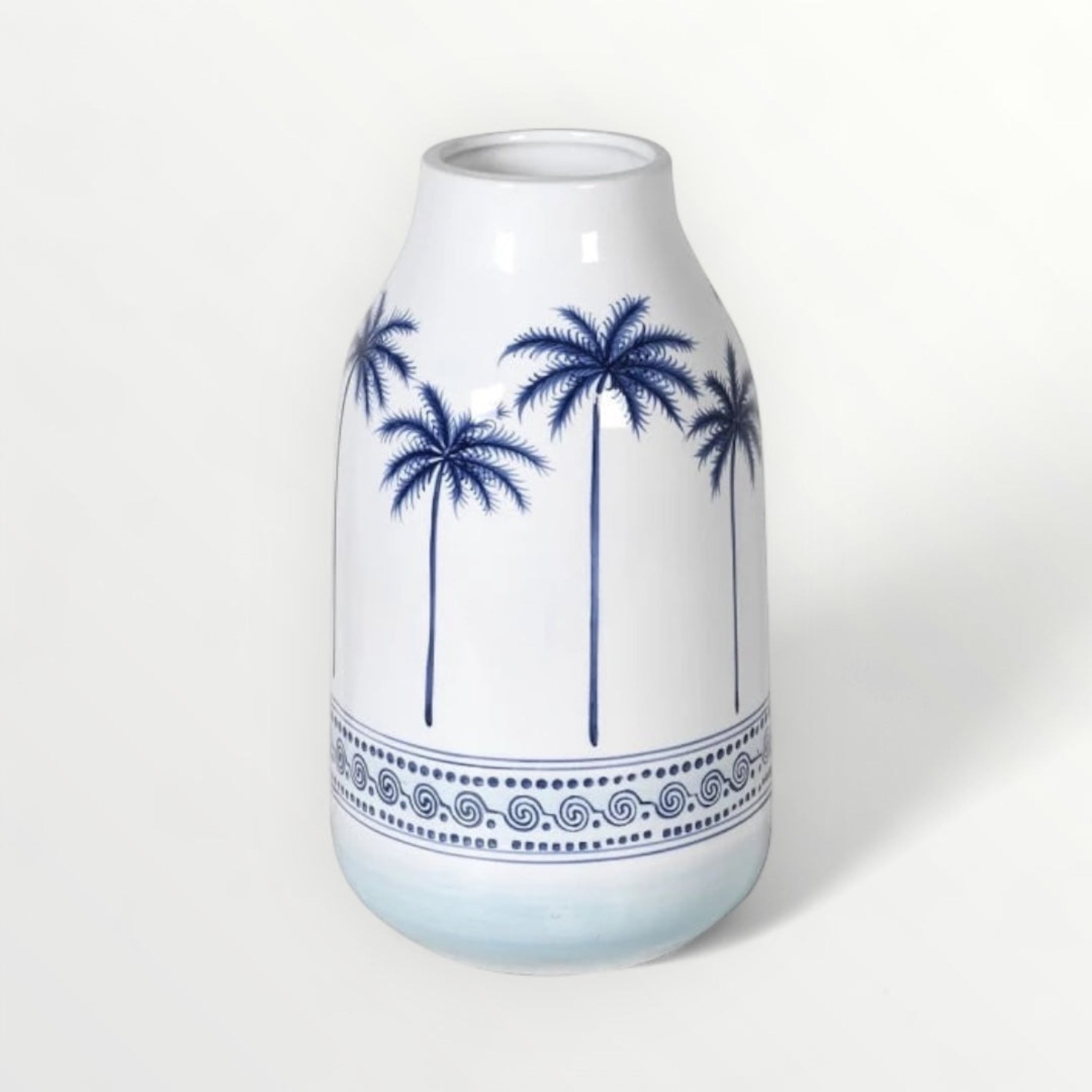 A white ceramic vase with blue palm tree and intricate border detailing.