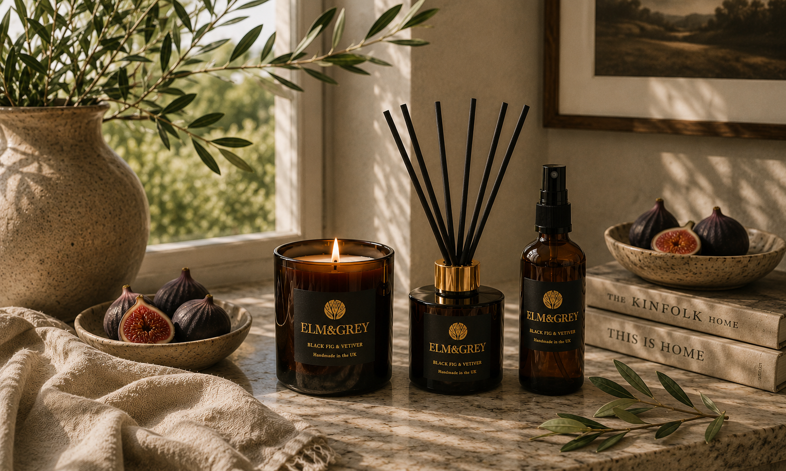 Elm & Grey Black Fig & Vetiver home fragrance collection featuring luxury candle, reed diffuser and room spray styled with figs and olive branches in a calm interior.