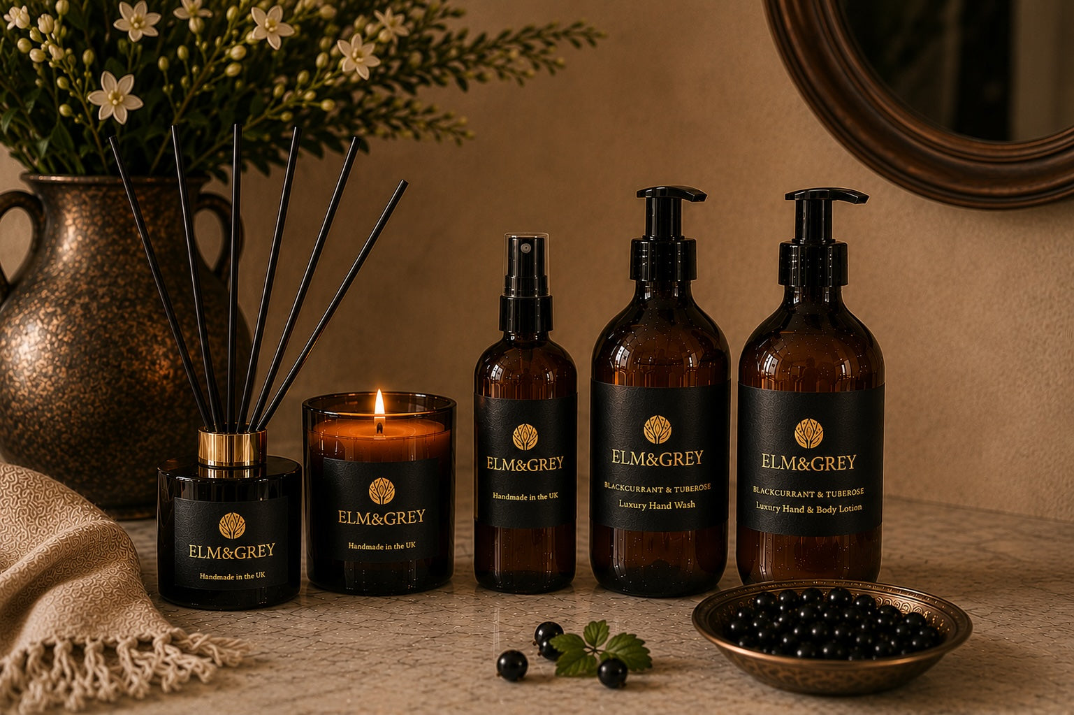 Blackcurrant and tuberose fragrance collection by elm and grey styled on a marble surface with flowers and botanicals