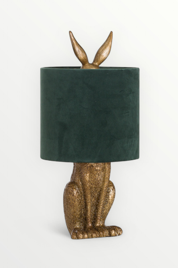 Decorative lamp with gold rabbit base and green velvet shade on a white background