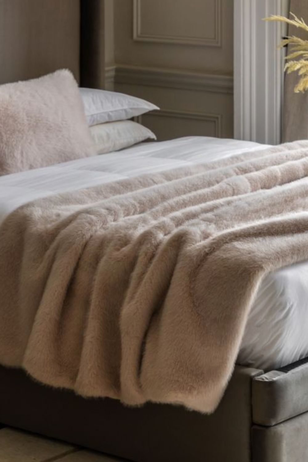 Beige oatmeal blanket draped over a bed in a bedroom setting