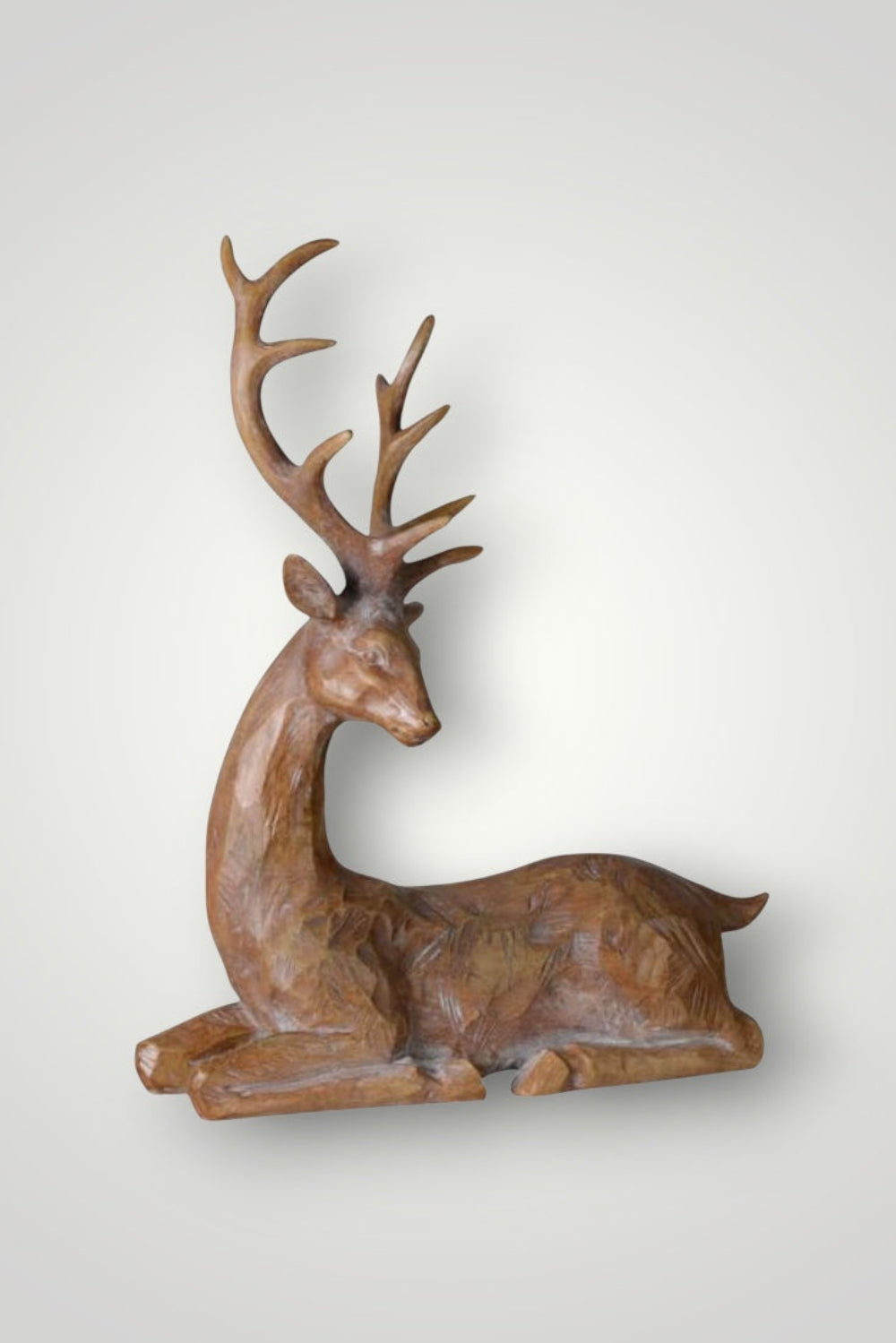 Wooden deer figurine with large antlers on a white background