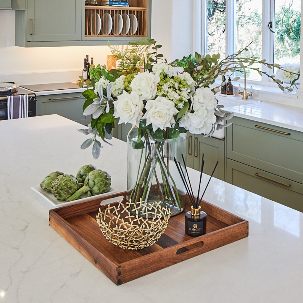 Brass Bowl on a tray in a kitchen with elm and grey diffuser and white roses with pussy willow arrangement