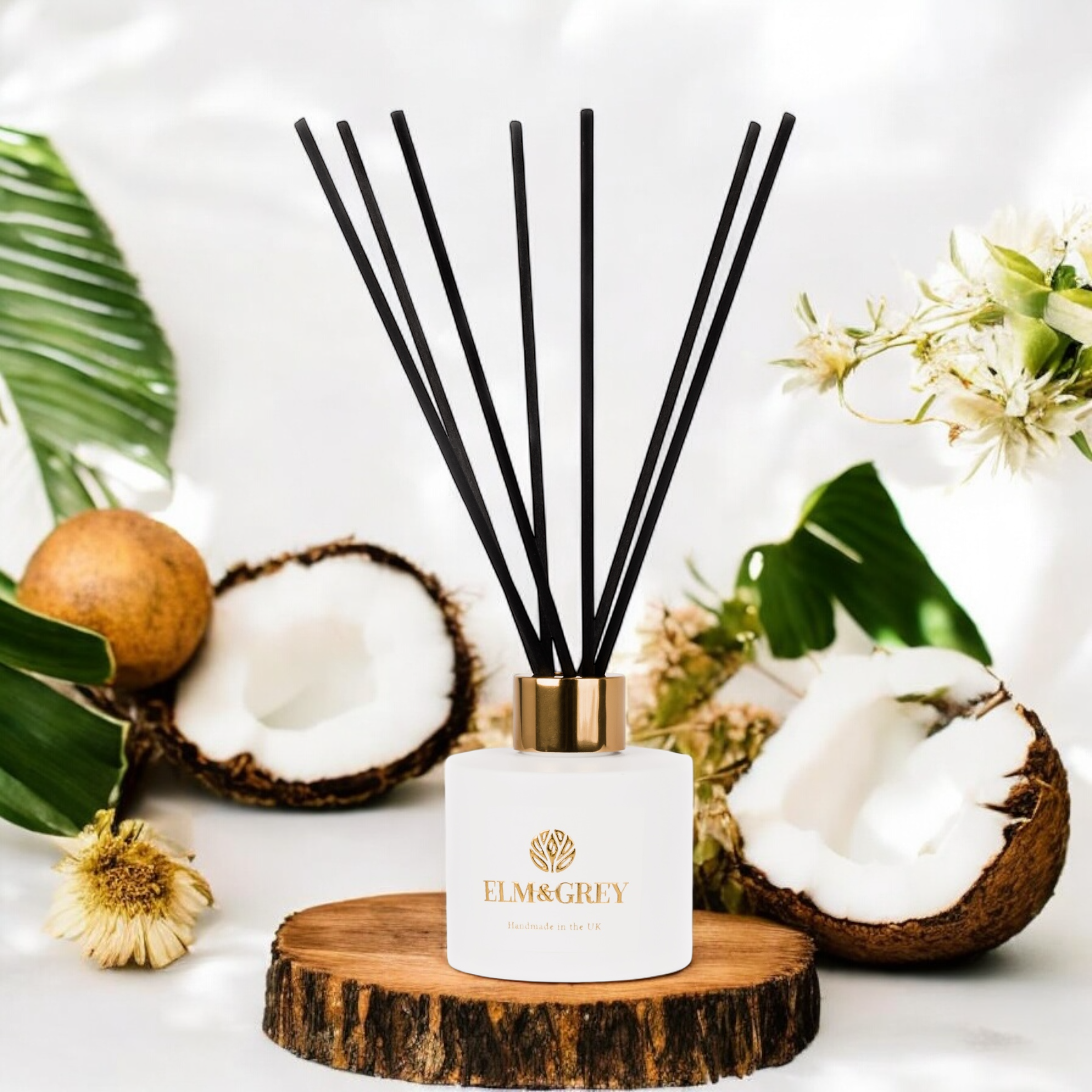 Reed diffuser with coconuts and leaves on a white background