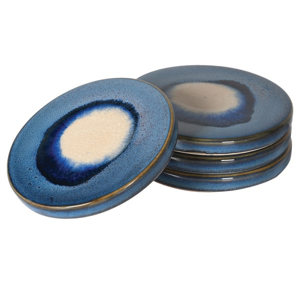 A set of four ceramic coasters with a reactive glaze in blue and ivory tones, displayed against a neutral background.