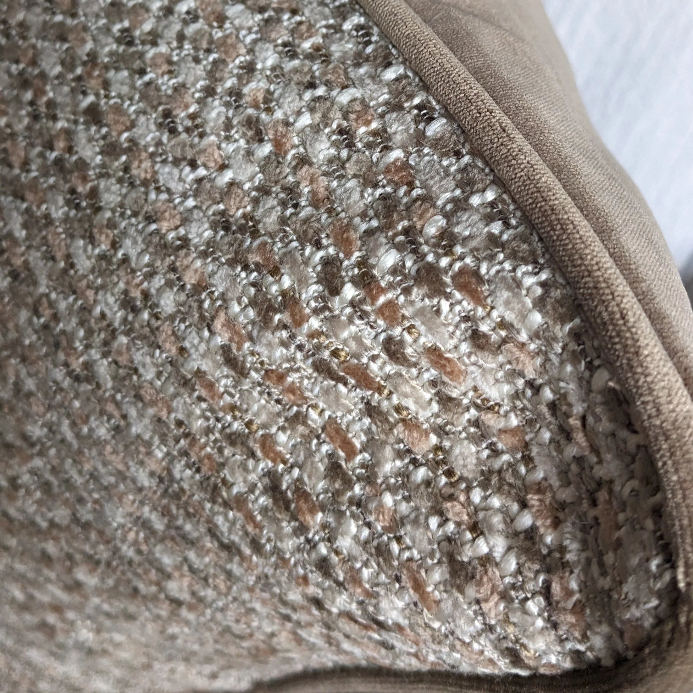 Close-up of a textured fabric surface with a neutral color palette.