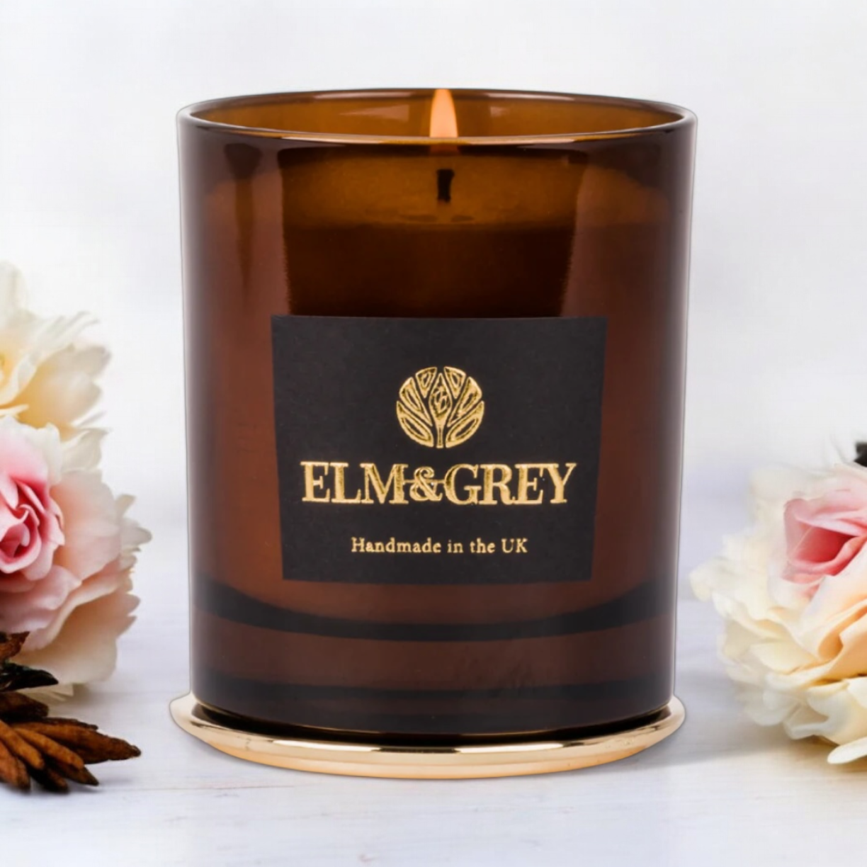 Amber candle container jar surrounded by peony roses and oud