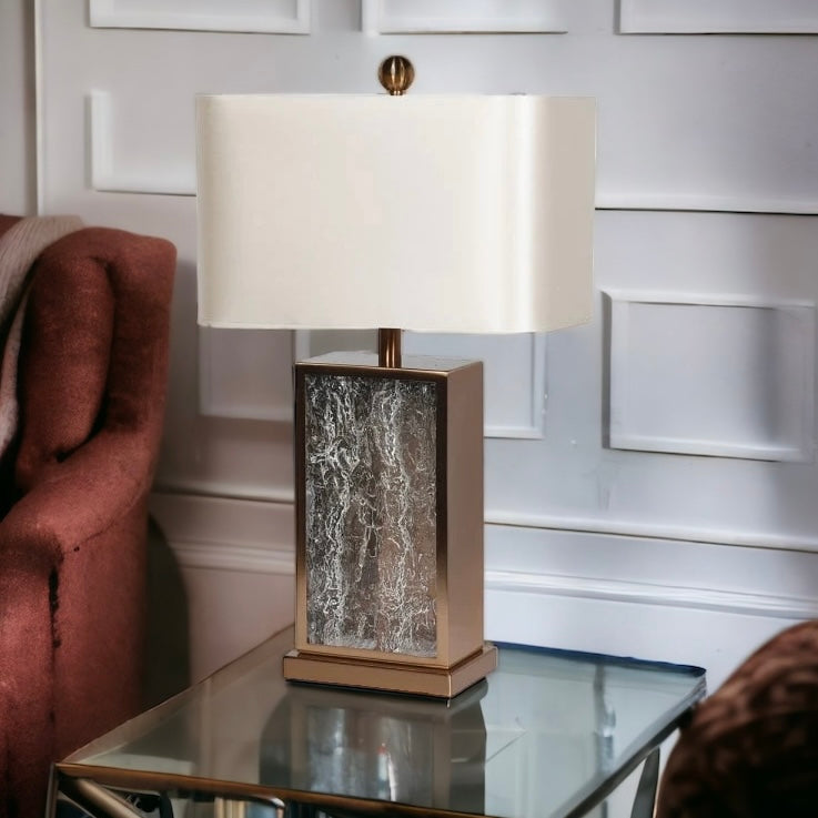 Bronze coloured textured glass table lamp on a glass topped table in a home