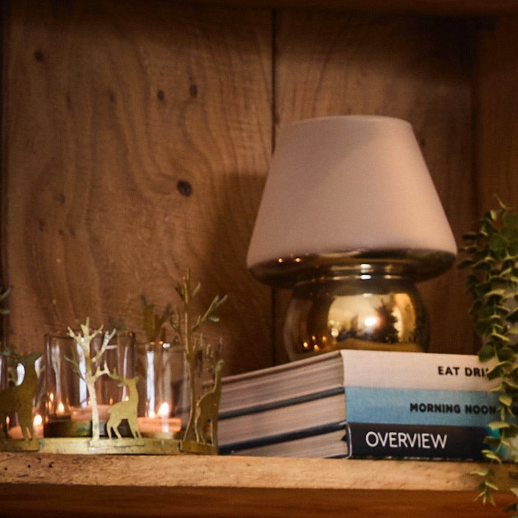 Gold and White Mushroom candle holder on a pile of books