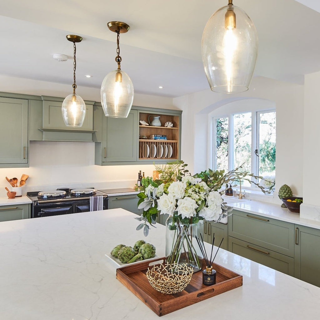 Elm & Grey Lime Basil & Mandarin Reed Diffuser on a tray with a floral arrangement decorative bowl on a white marble countertop in a kitchen