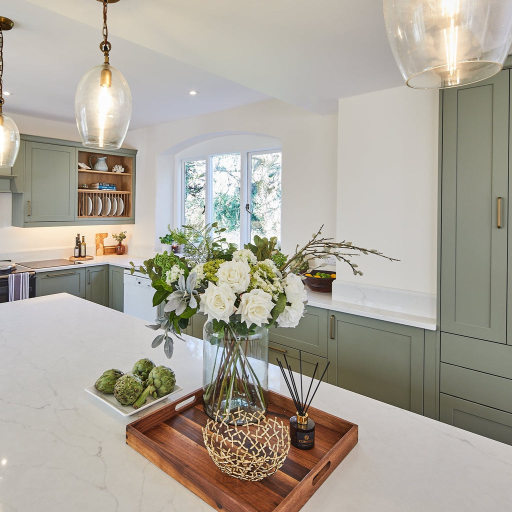 deluxe white roses and pussy willow in a vase in a white marble kitchen with sage coloured doors