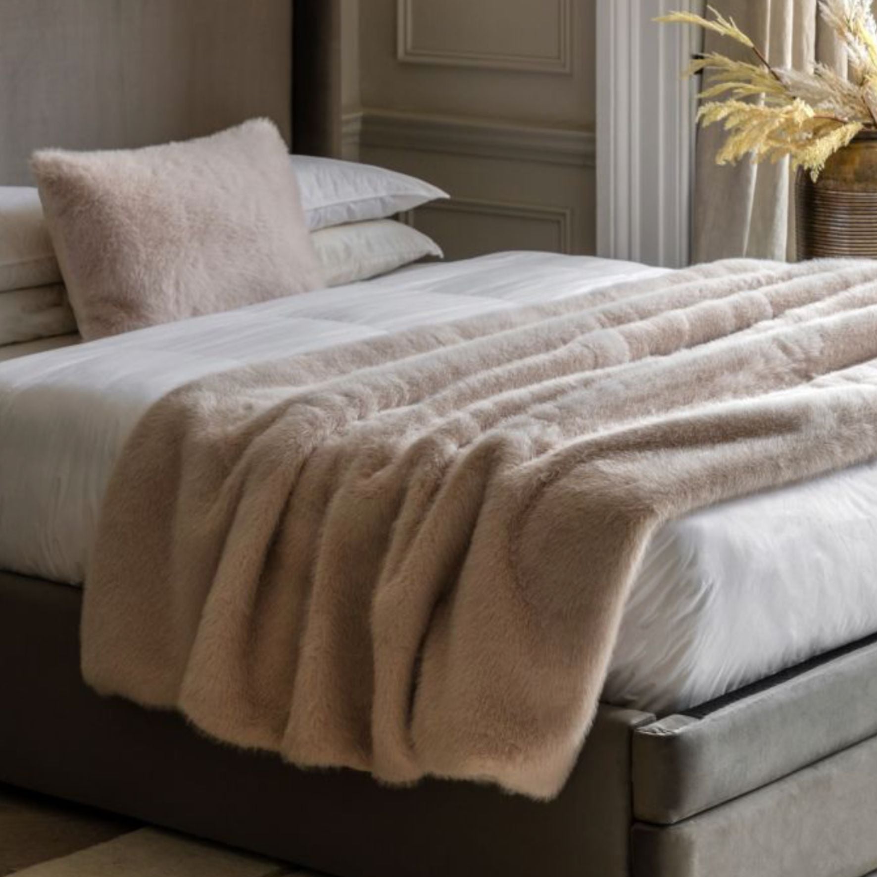 Beige oatmeal blanket draped over a bed in a bedroom setting